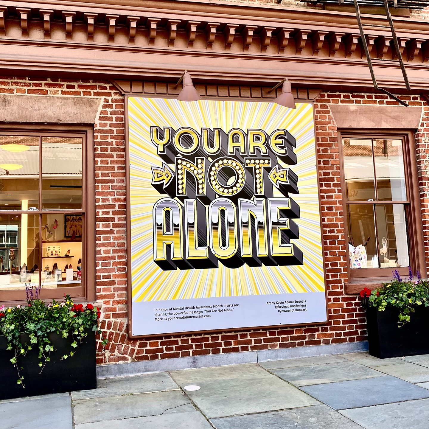 We are proud to showcase such a powerful message throughout the Seaport in collaboration with @youarenotalonemurals.  #MentalHealthAwarenessMonth #YouAreNotAloneArt : @kevinadamsdesigns