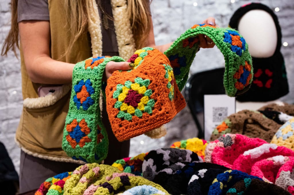 vendor holding hand-knitted goods