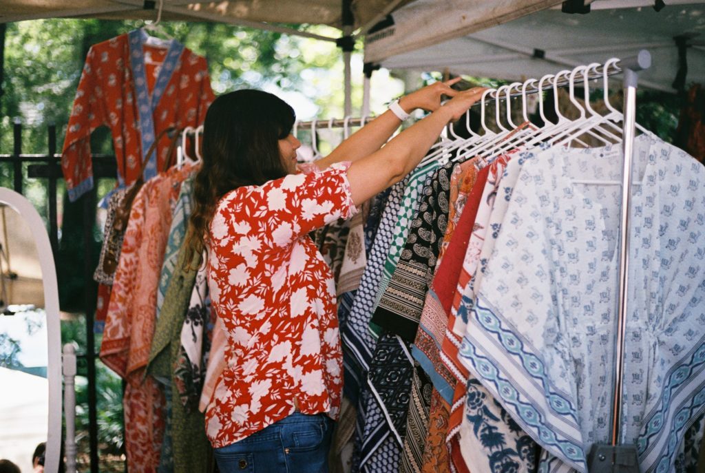 woman shopping for clothes at an outdoor market