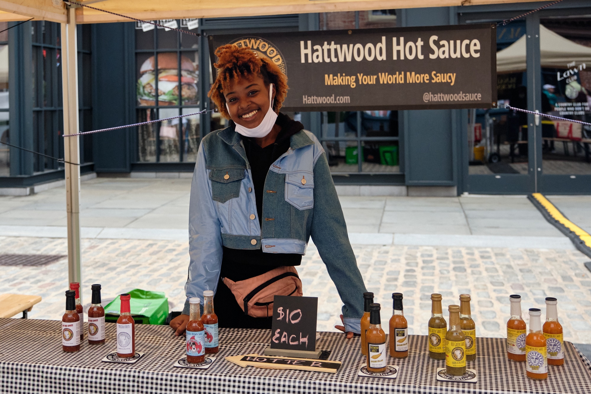 woman at the Hattwood Hot Sauce table with hot sauces at the Hester Street Fair