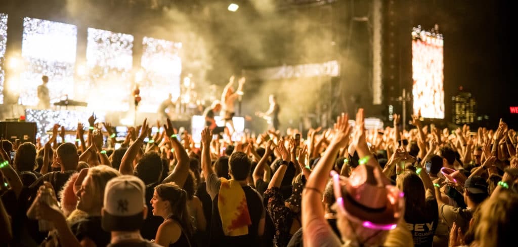 crowd at a concert with their hands up