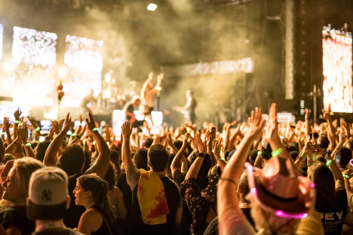 crowd at a concert with their hands up