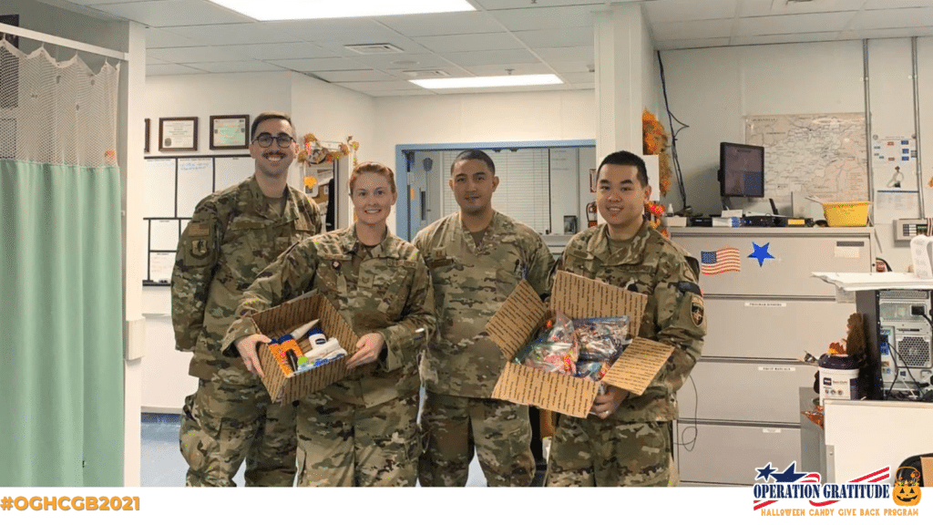 Army service members holding donated candy from Operation Gratitude