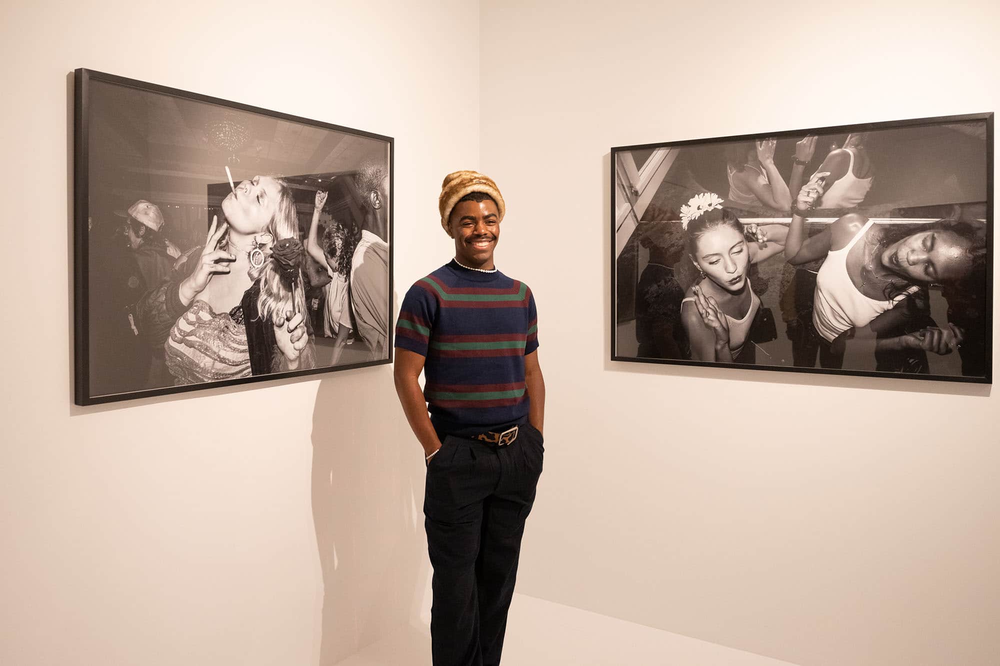 Tyrell Hampton standing with two of his photos in the SN37 Gallery