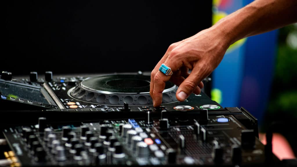 hand hovering over a DJ turntable during a set