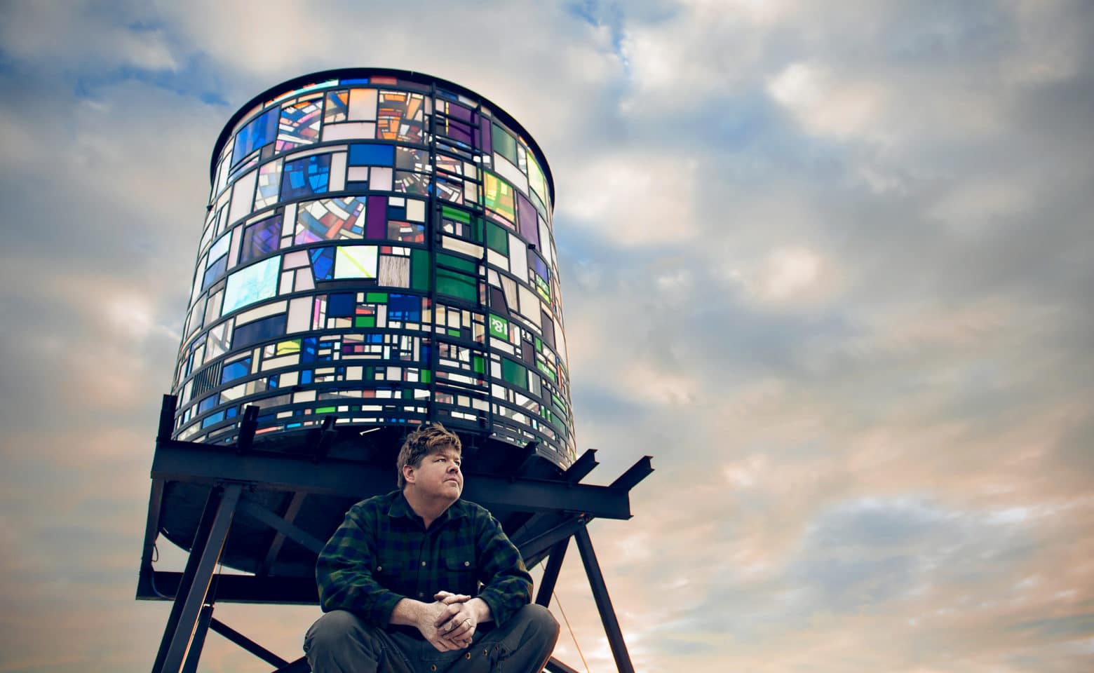 Tom Fruin in front of his stained glass watertower creation