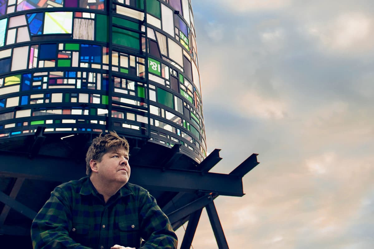 Tom Fruin posing in front of his Watertower creation
