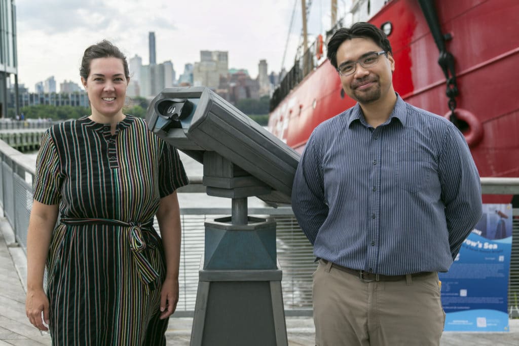 artists standing next to a virtual viewfinder next to East River
