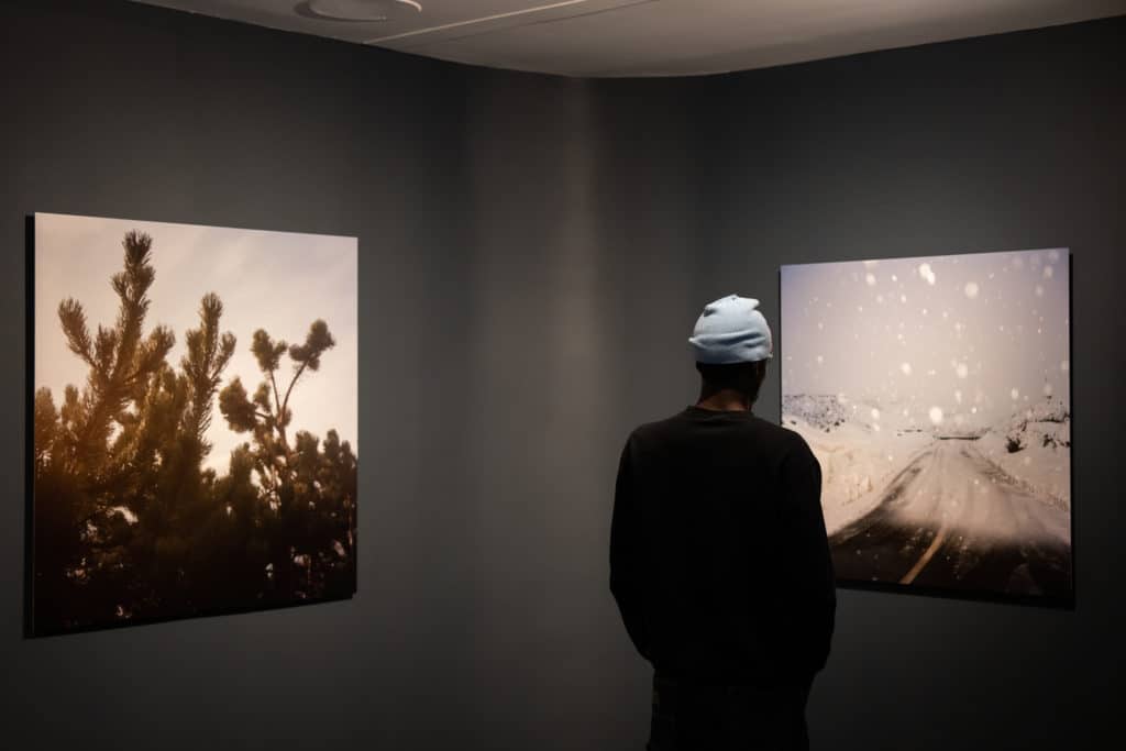 man looking at a photograph inside SN37 Gallery