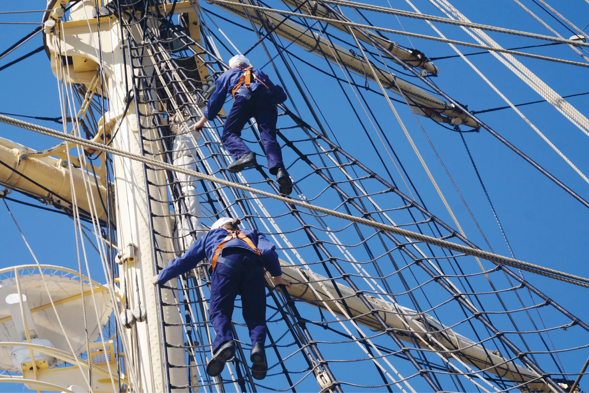 Two sailors climbing up the sail net