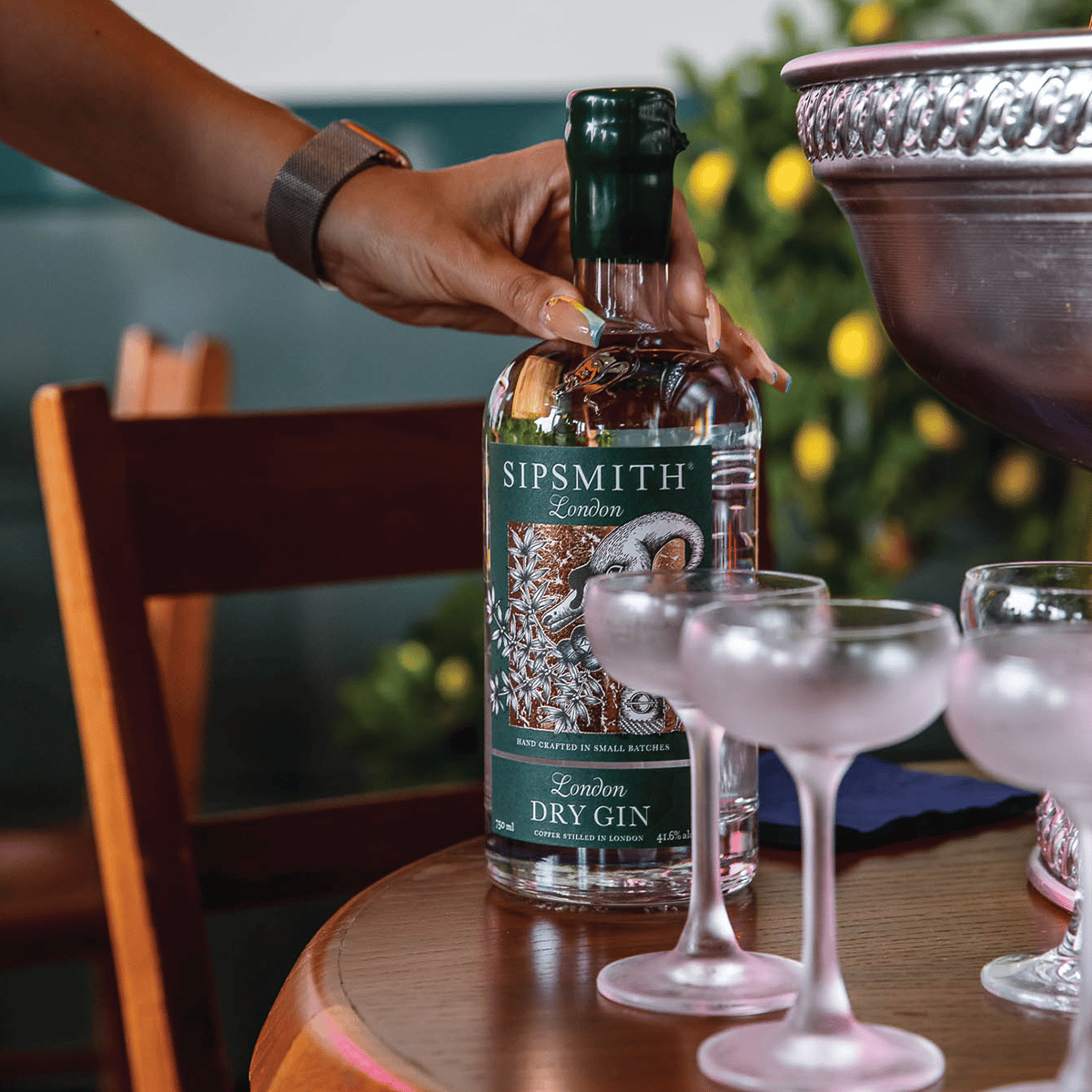 a closeup of Sipsmith gin bottle with glasses on table
