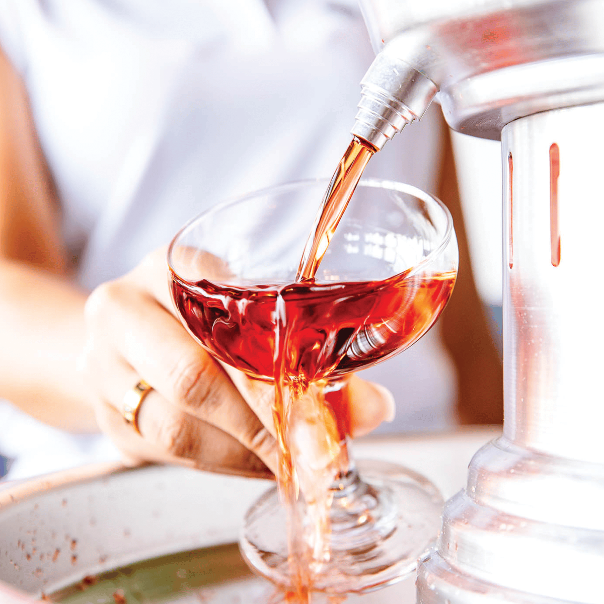 a closeup of cocktail pouring in a glass