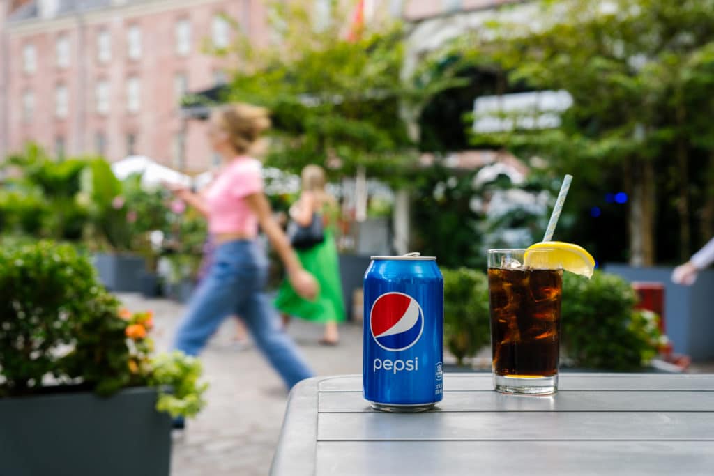 Pepsi can with a glass of Pepsi with lemon on outdoor table in Seaport