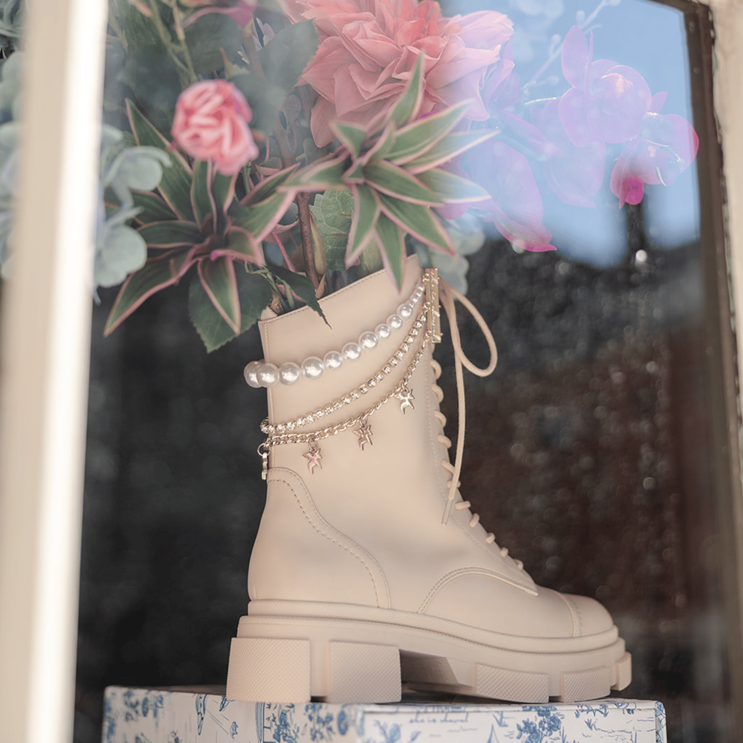 Beige combat boot decorated with roses and pearls on window display at She is Cheval pop-up at the Seaport