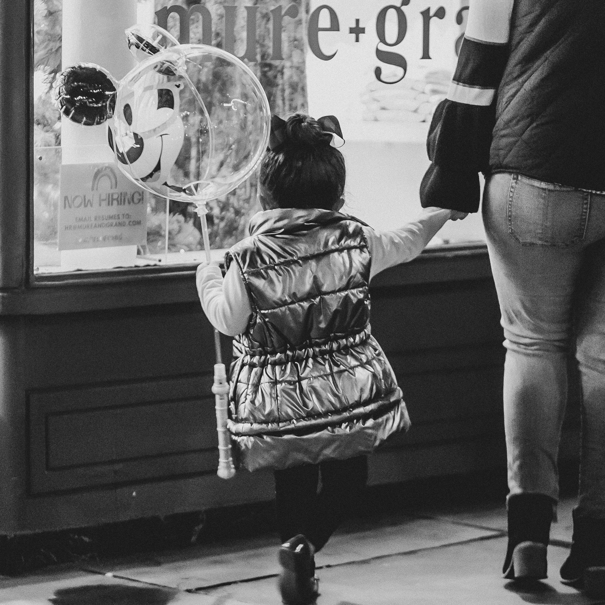 child walking with a balloon and holding mom's hand in the Seaport