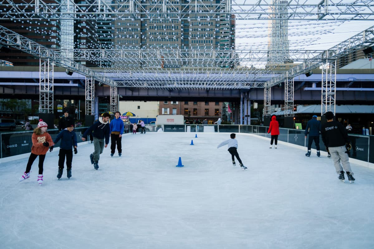 people skating at the ice rink at the seaport