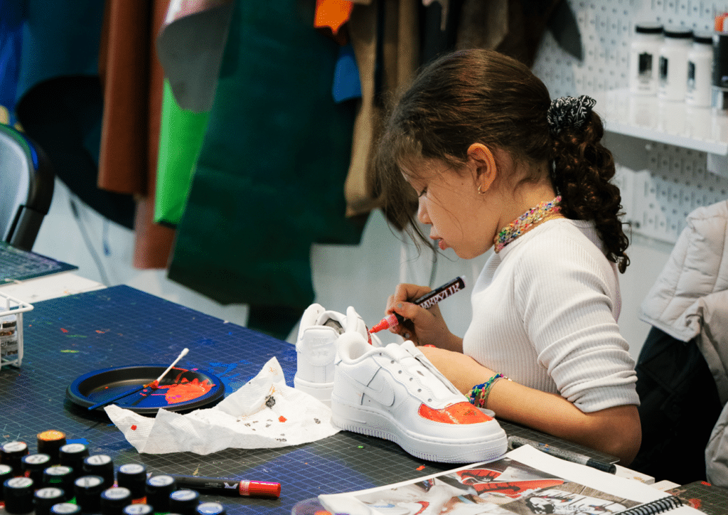 child customizing sneakers at a Shoe SRGN lab in the Seaport