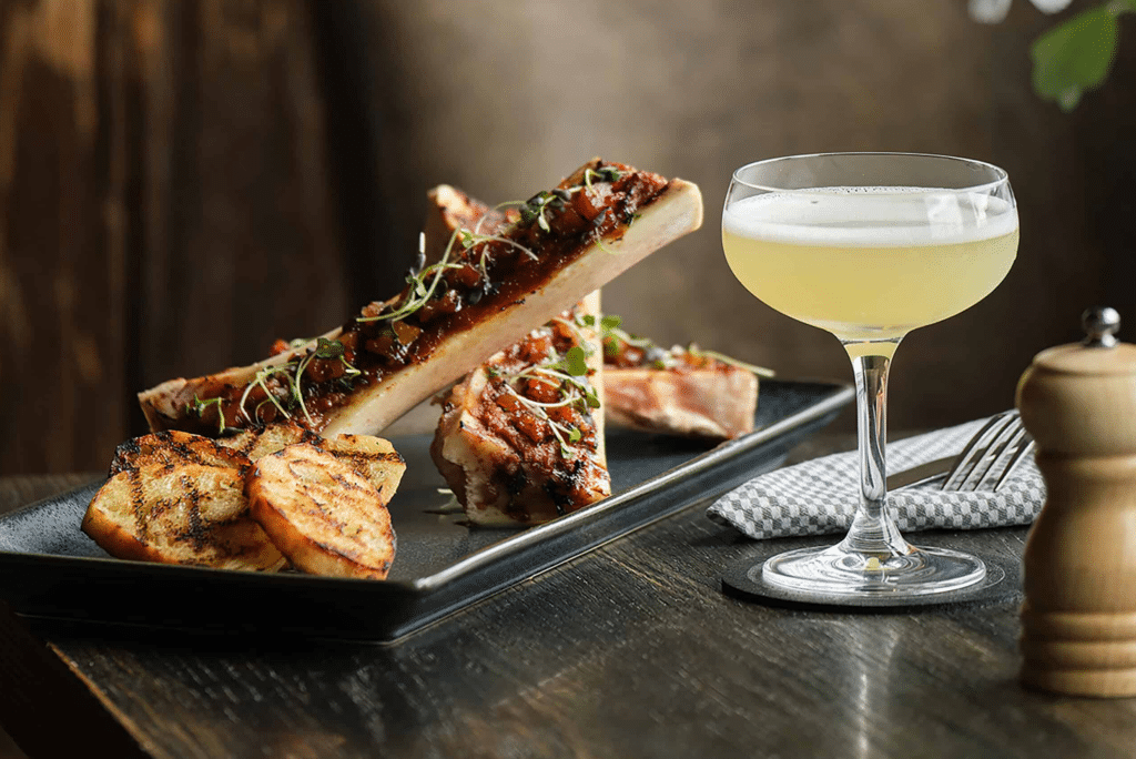 a plate with bone marrow and a cocktail at the tuck room at the seaport