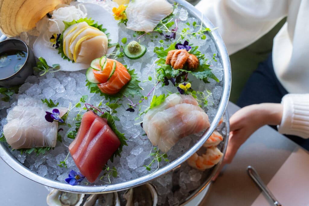 A person is holding a Seafood plateau at the Fulton