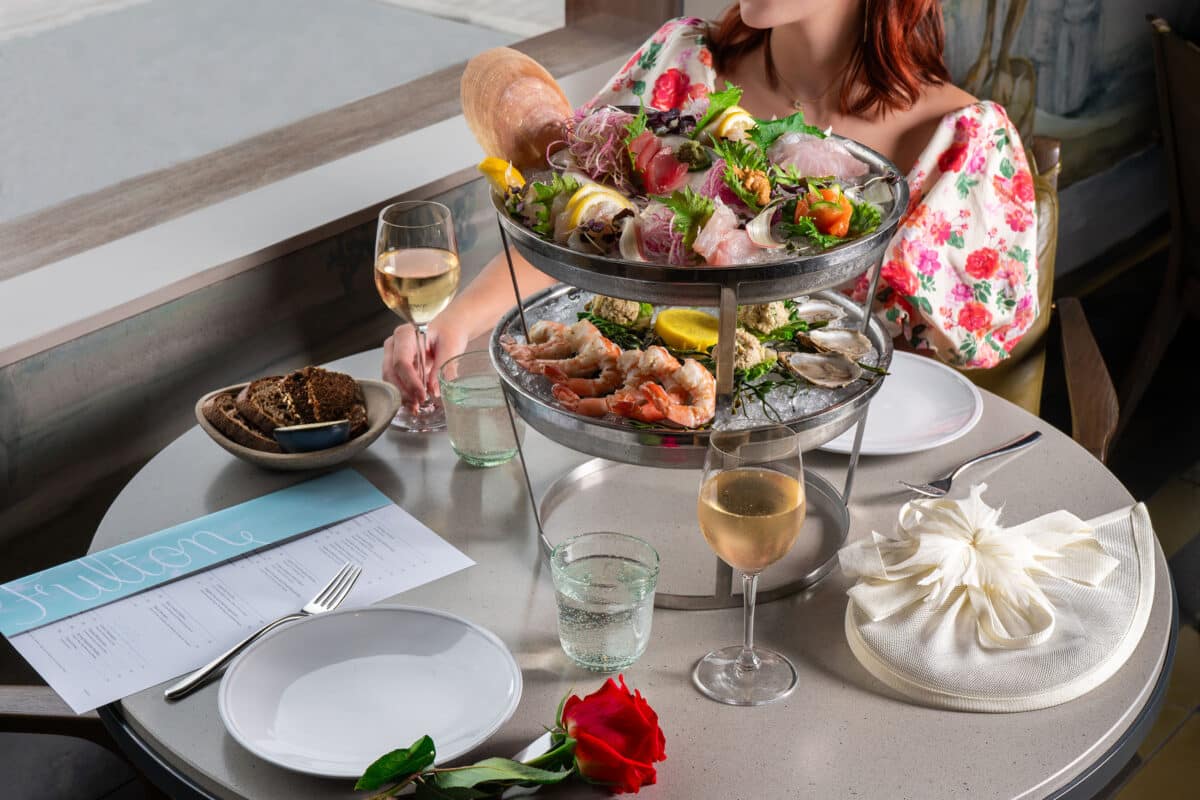 seafood plateau with a lady in a floral dress and a hat in the background
