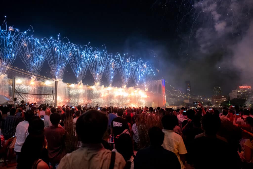 fireworks being set off from the brooklyn bridge on the fourth of july at the seaport