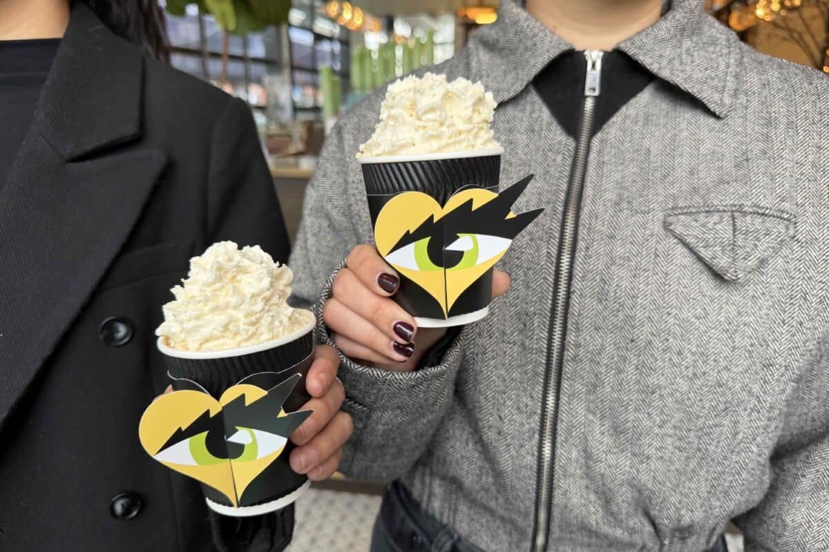 two women hold cups of Hot Ice Cream with the SMiZE logo at T.Cafe.