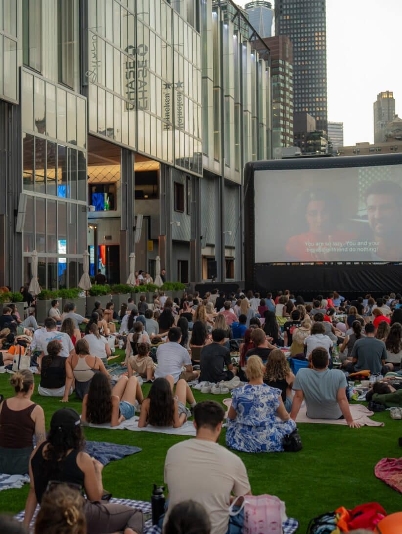 a group of people watch an outdoor movie at the heineken riverdeck at the seaport