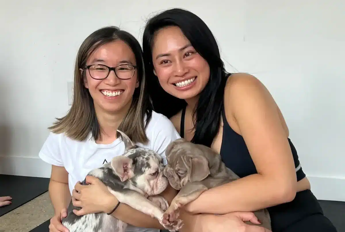 two women cuddle puppies at a puppy sphere yoga class