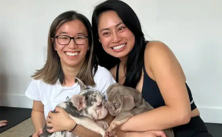 two women cuddle puppies at a puppy sphere yoga class