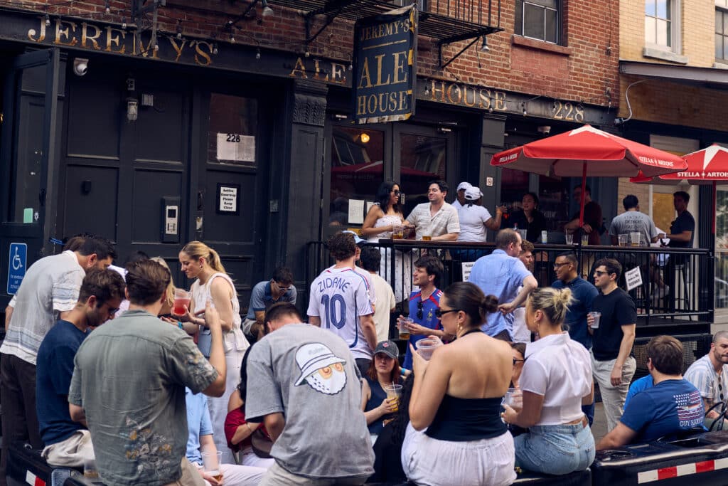 people sitting outside of jeremy's ale house at the seaport