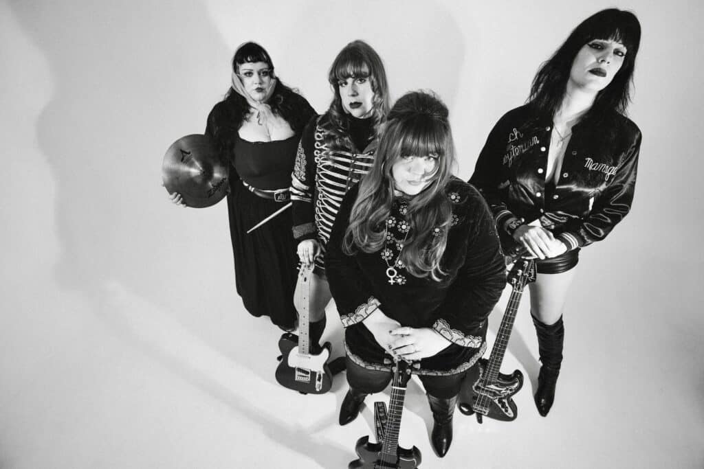 Abby Jeanne & the Shadowband; a black and white photo of 4 women, shot from above, wearing vintage clothing
