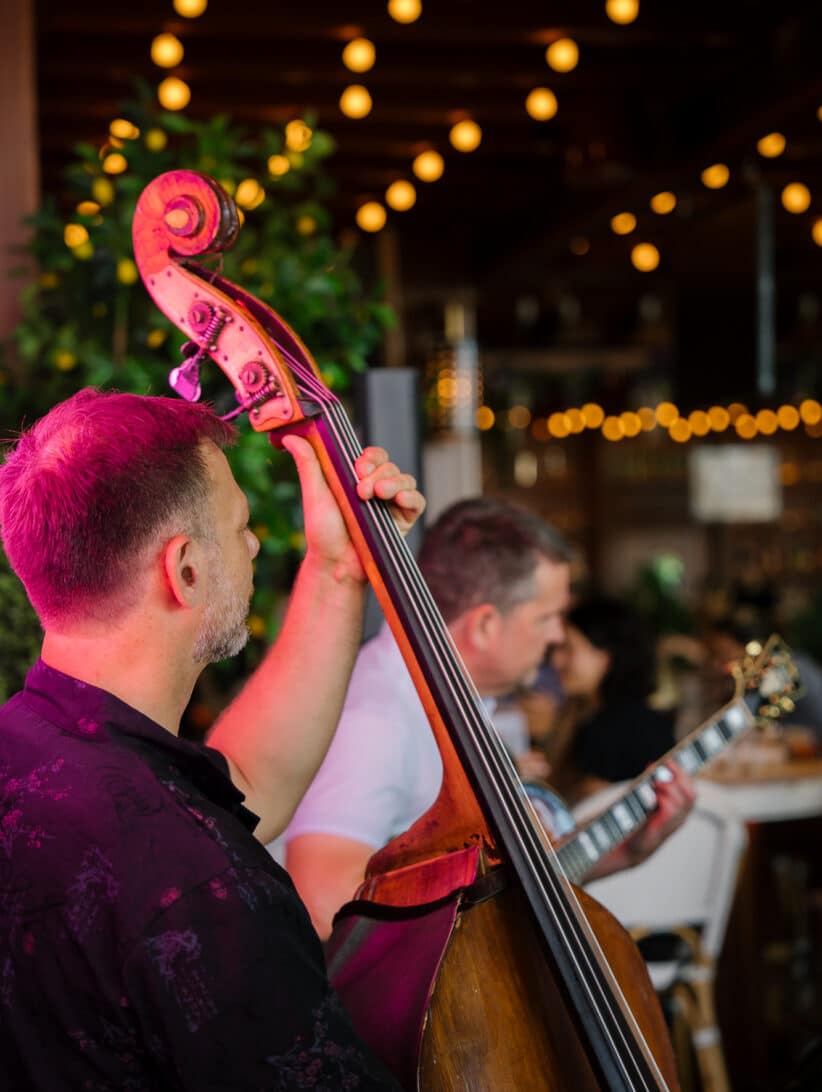 a man plays an upright bass in a bar